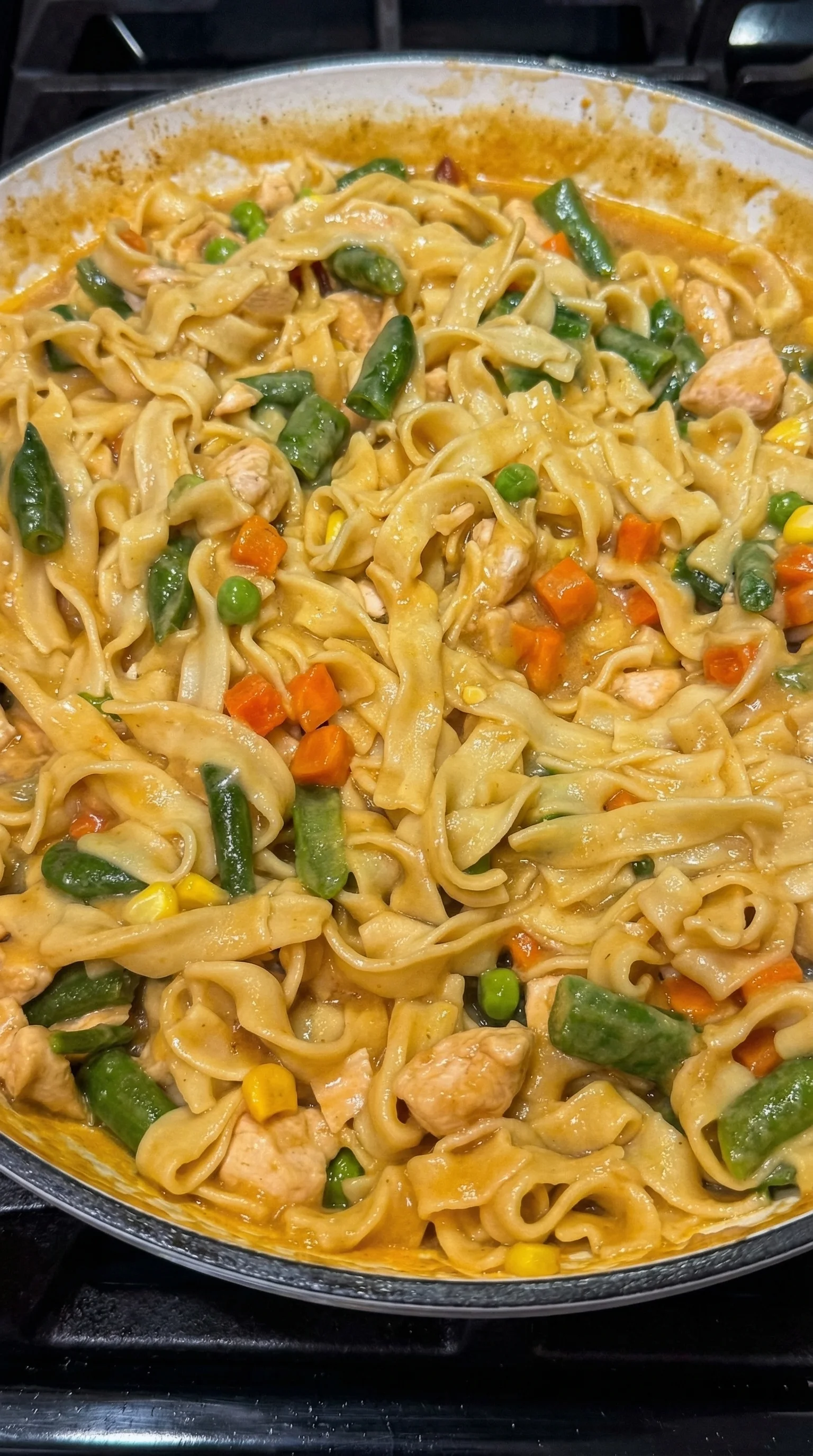 A bowl of noodles with vegetables.
