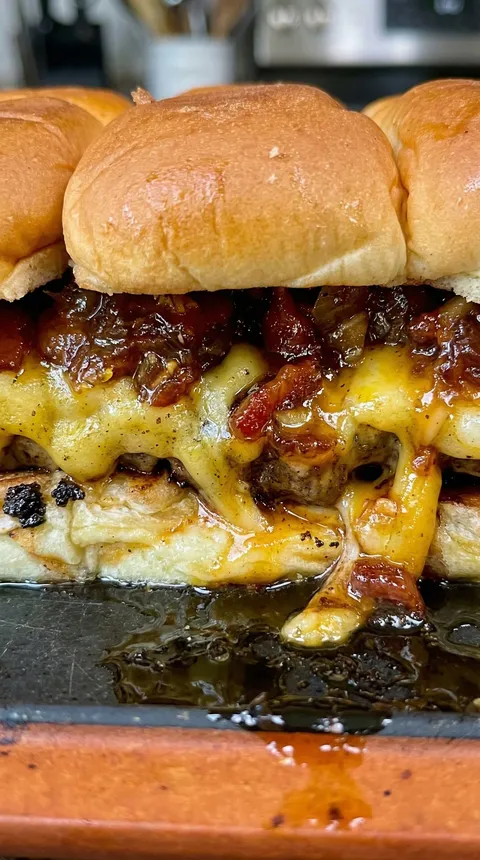 A close up of a cheeseburger with onions.