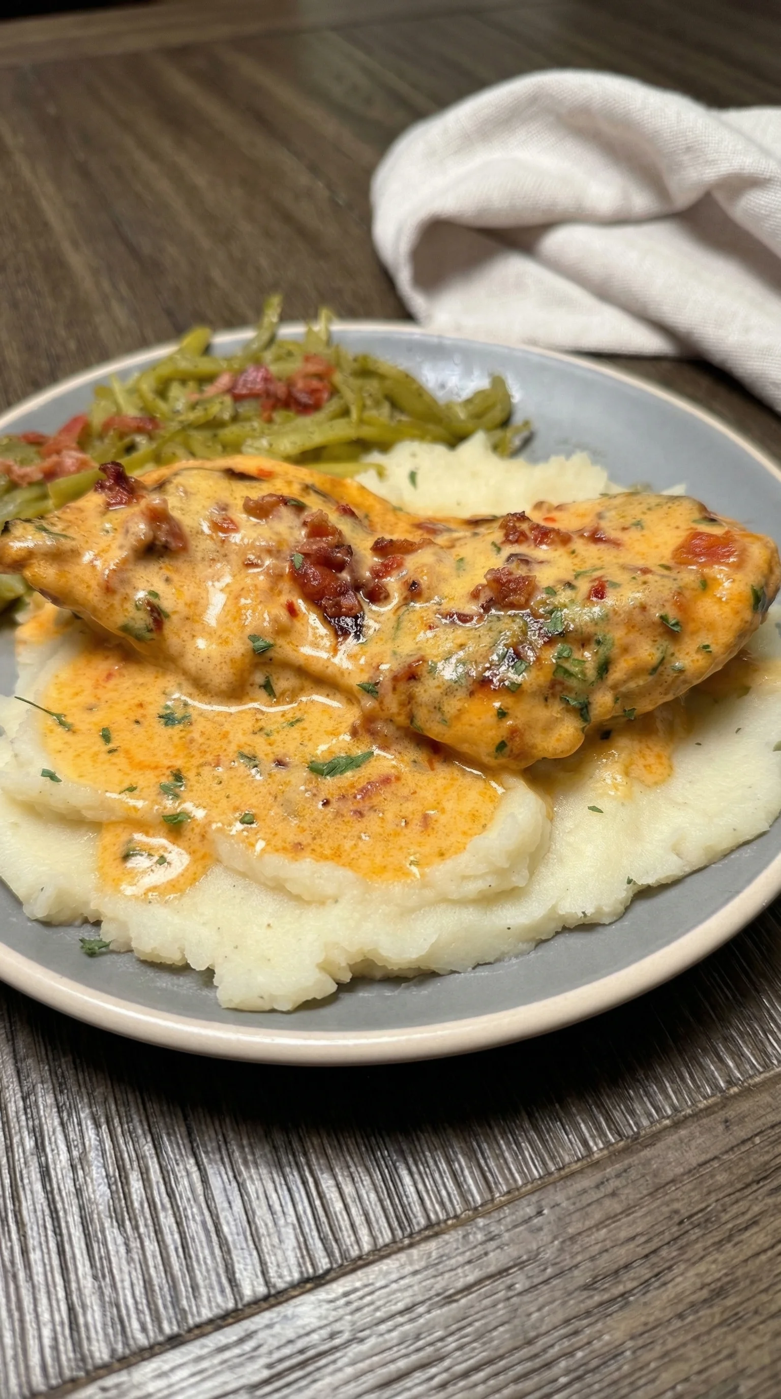 A plate of food with chicken, potatoes, and green beans.