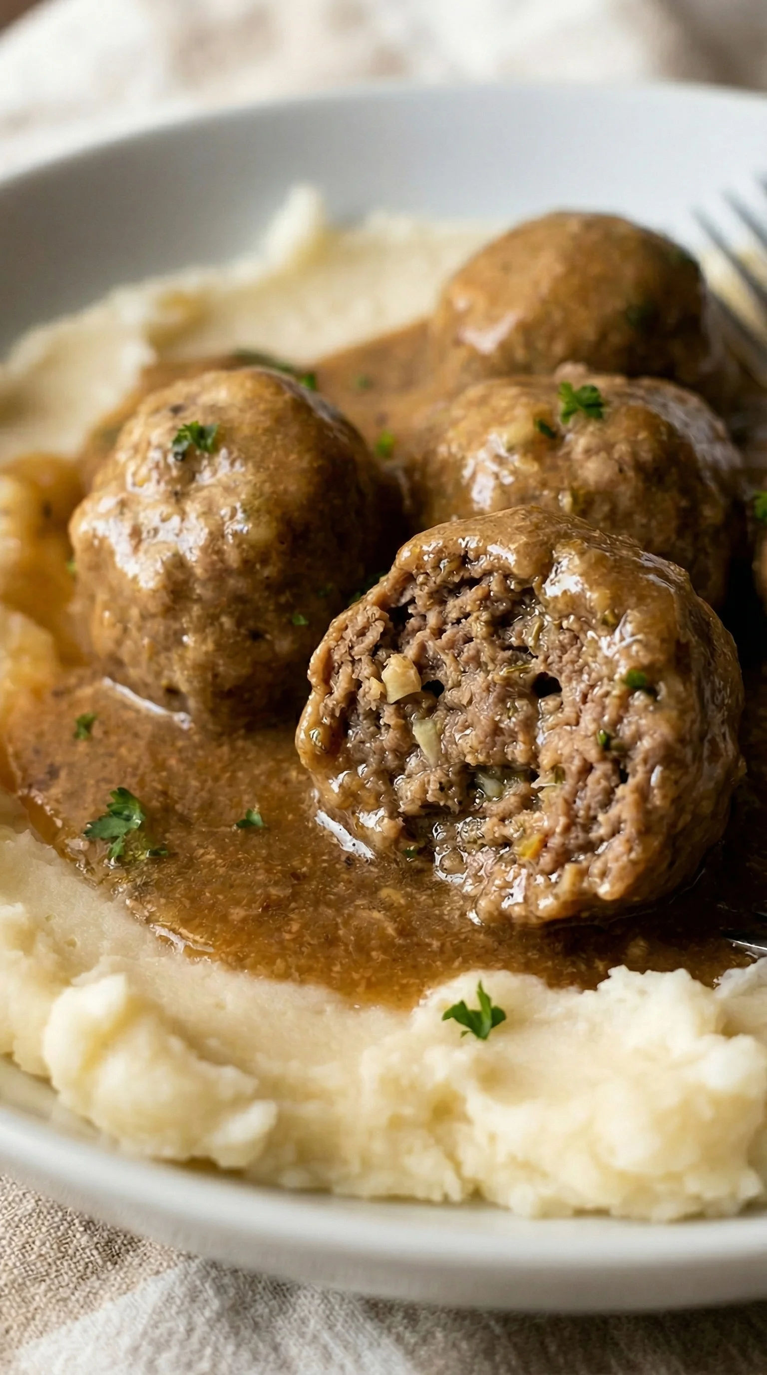 Meatballs in gravy with mashed potatoes.