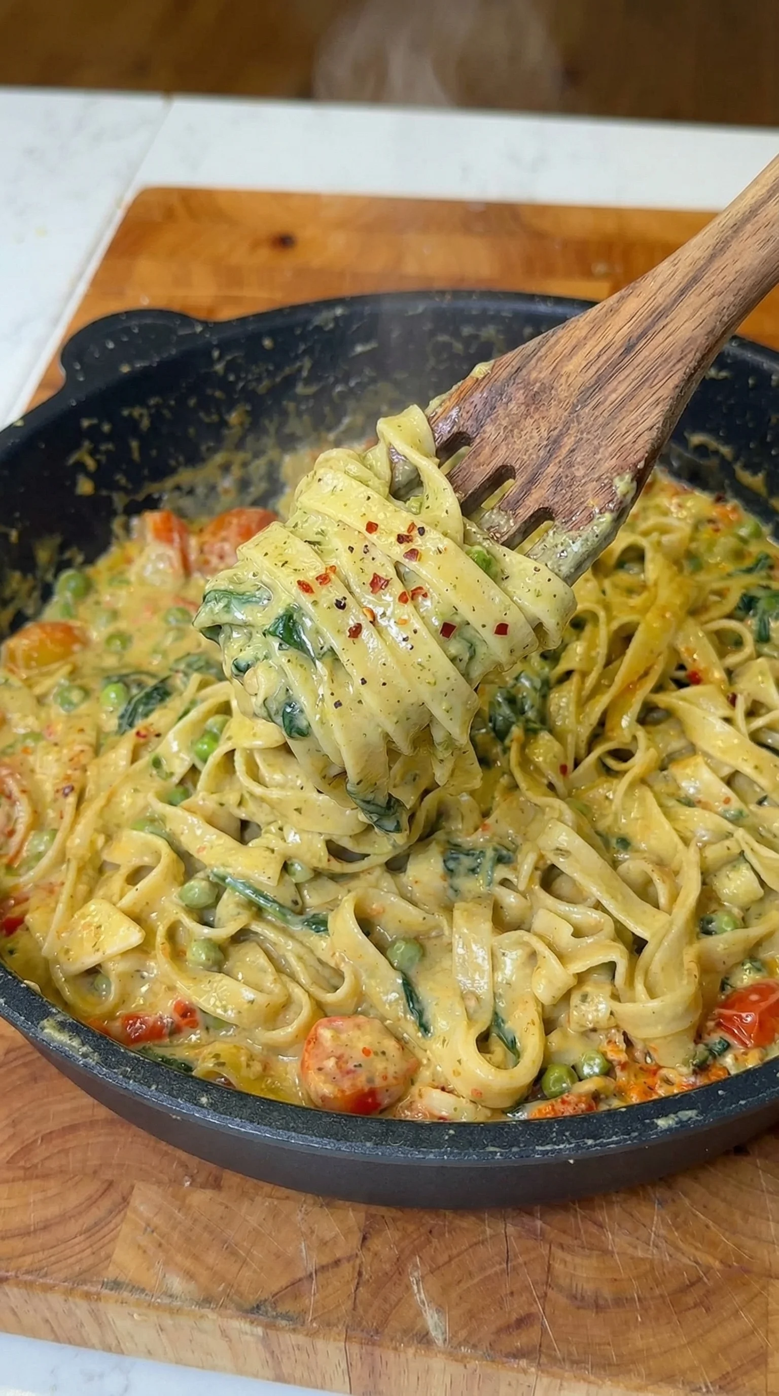 A wooden spoon is being used to scoop food from a bowl.