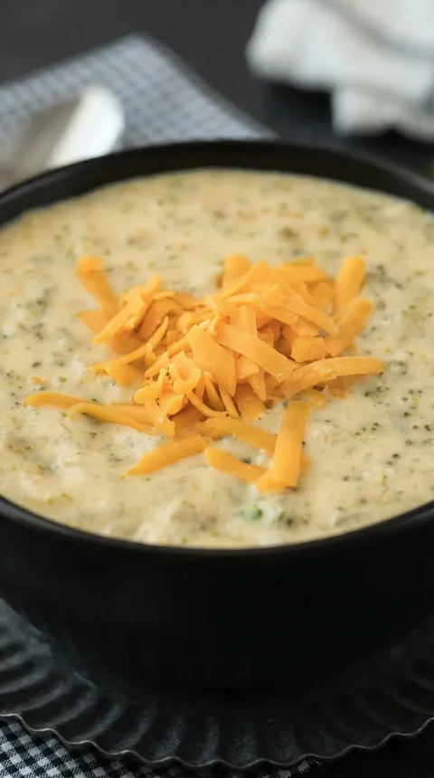 A bowl of soup with cheese on top.