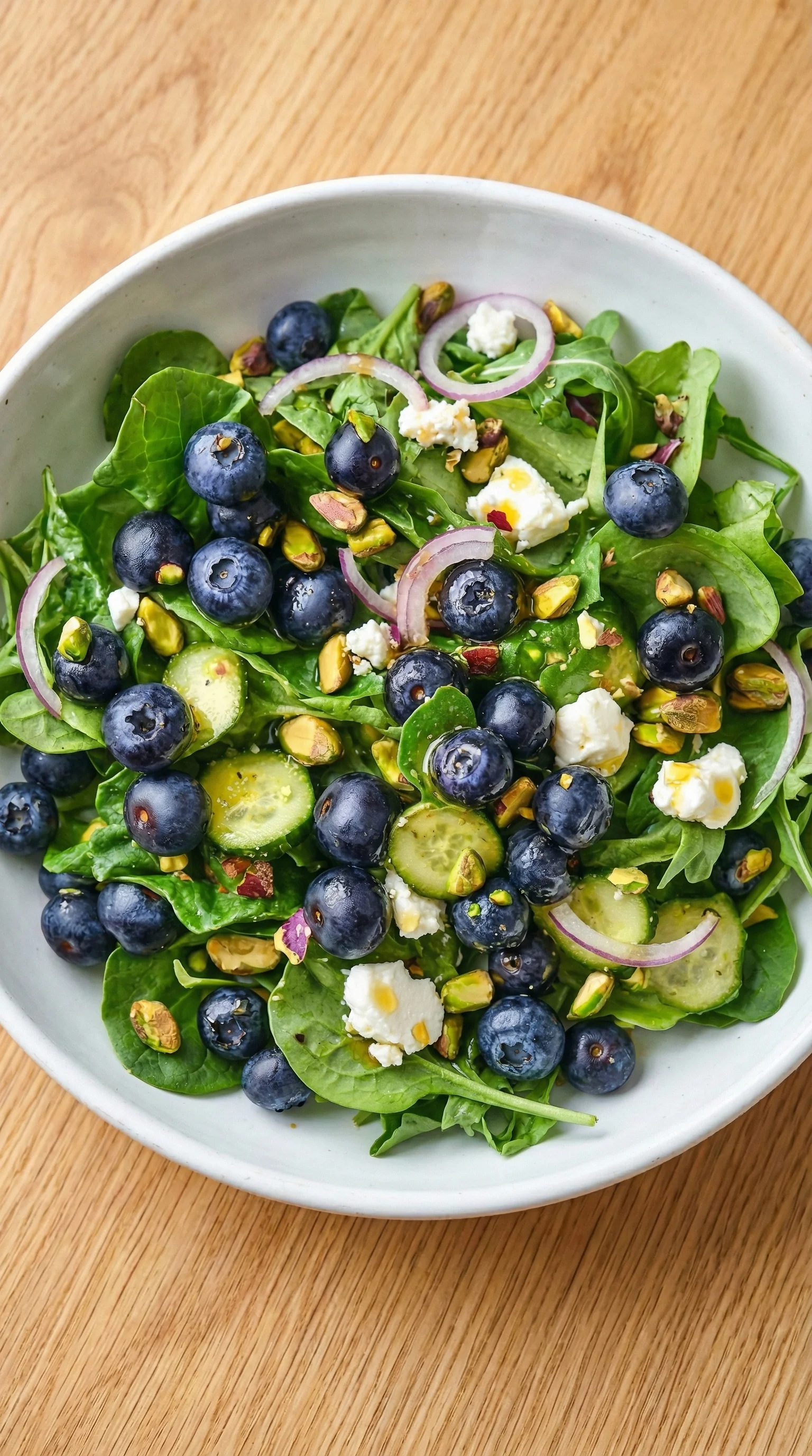 A bowl of blueberry pistachio spring salad.
