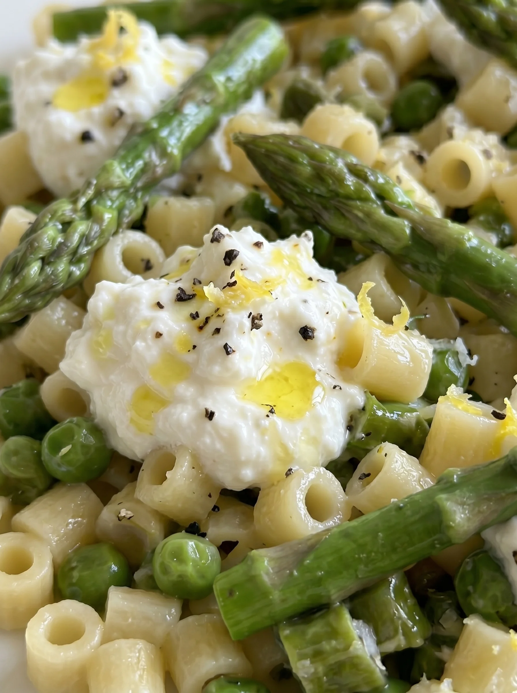 A dish of pasta with peas and asparagus.