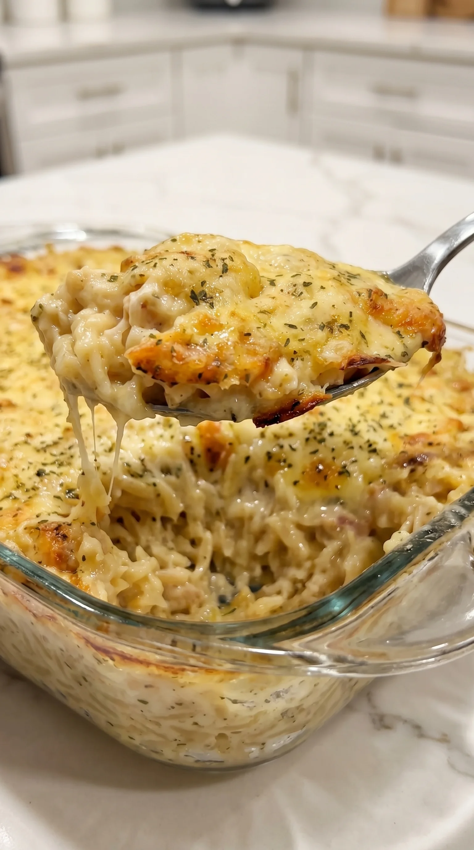 A fork is being used to eat a creamy lemon chicken orzo bake.