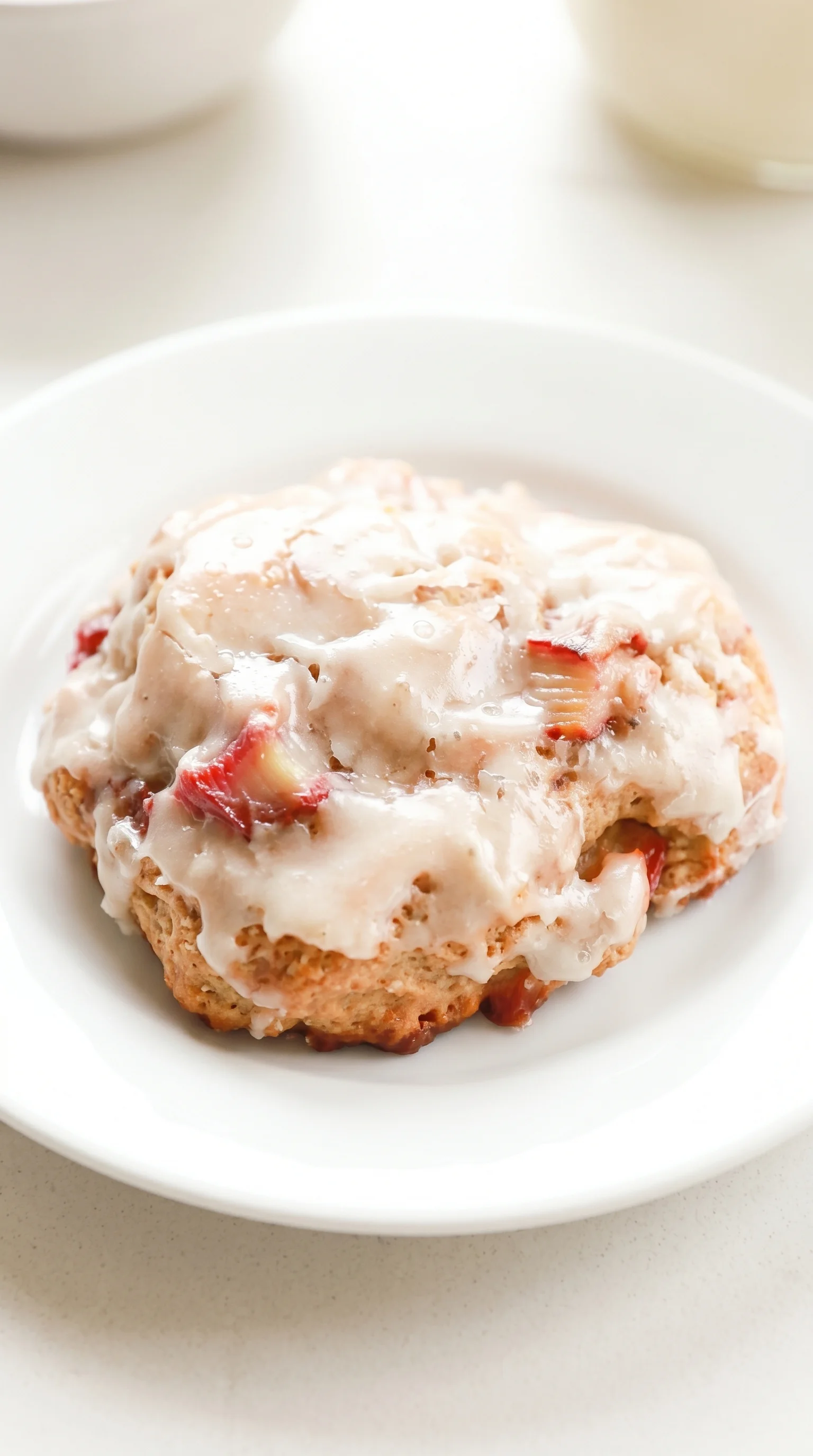 A baked rhubarb fritter on a white plate.