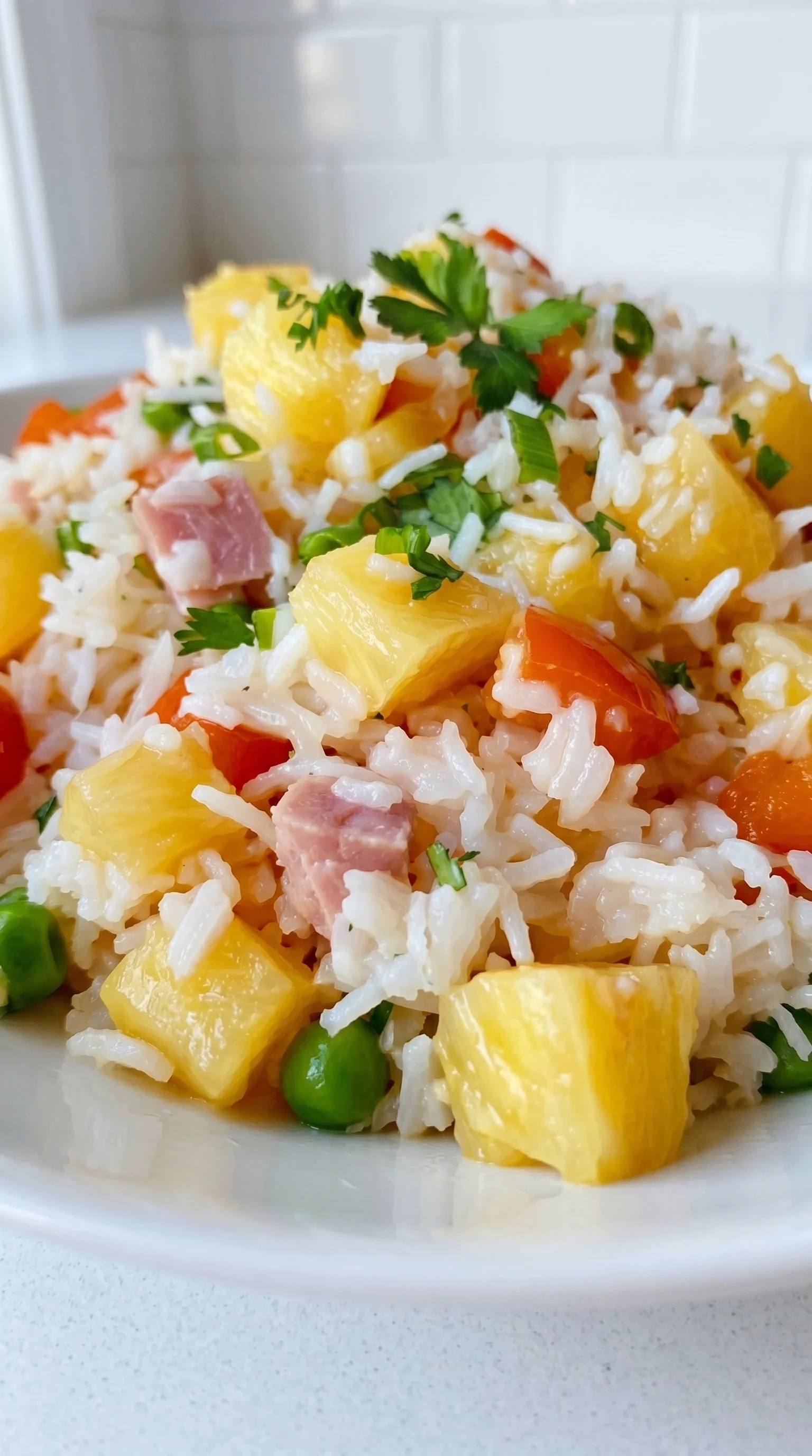 A plate of rice with pineapple and ham.