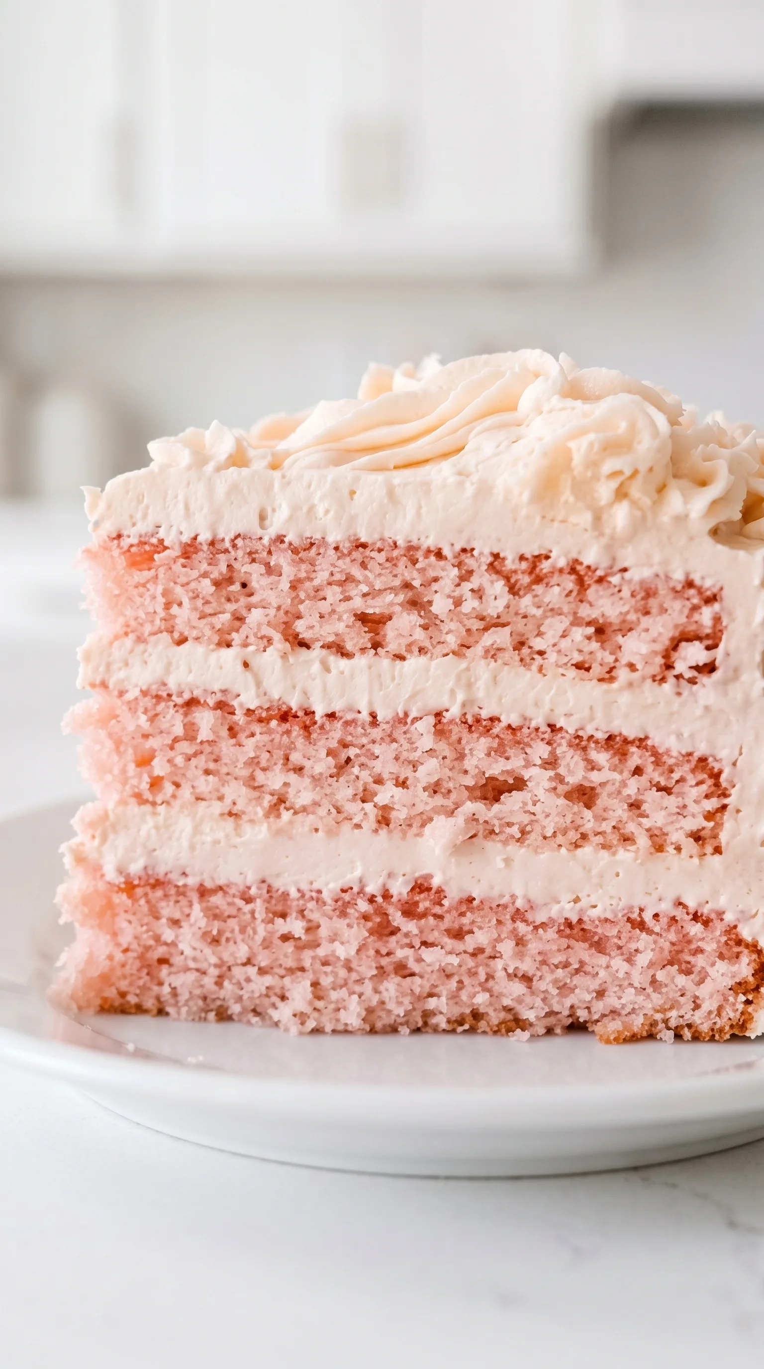A slice of pink cake on a plate.