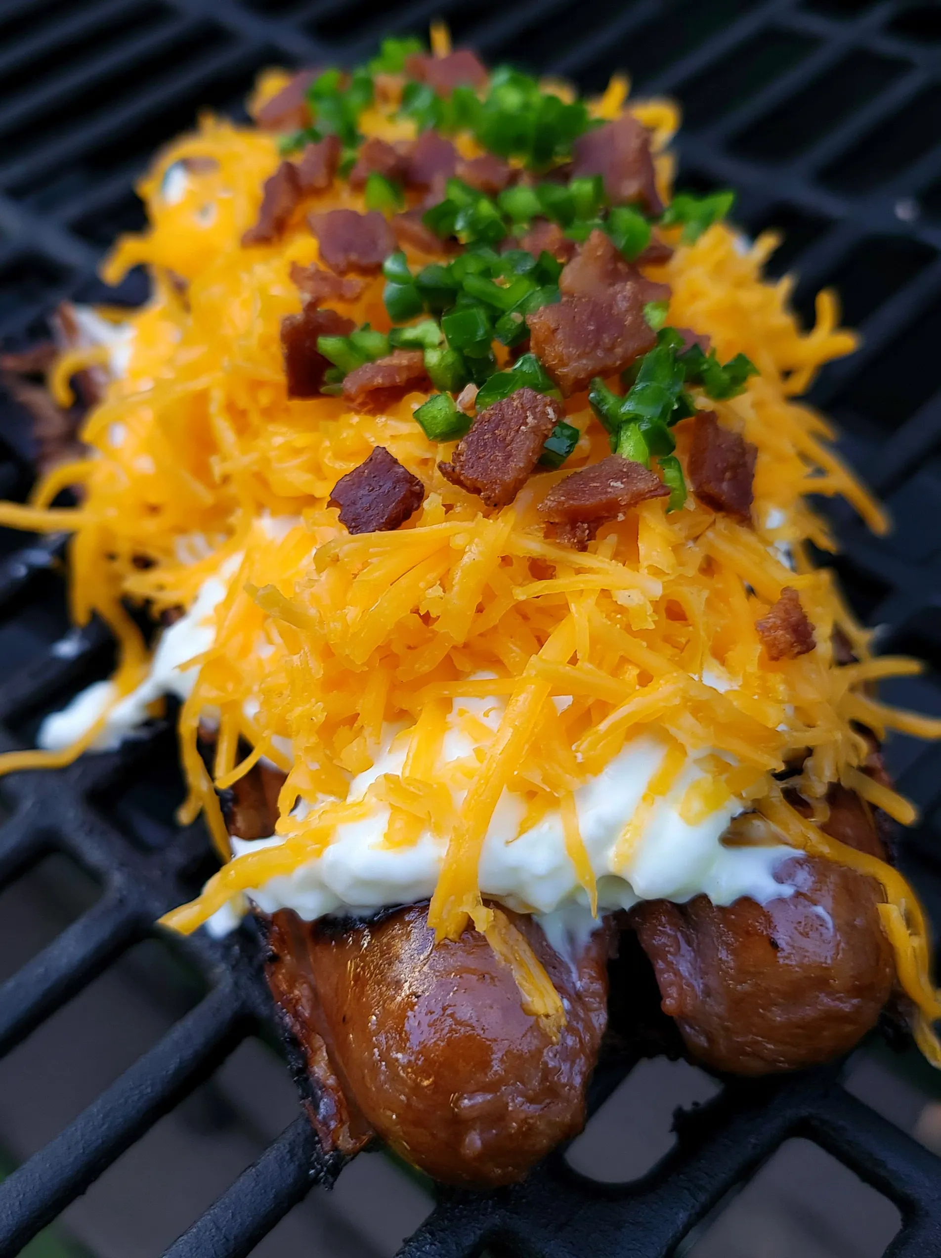 A grilled jalapeno popper sausage skewer with cheese and bacon.