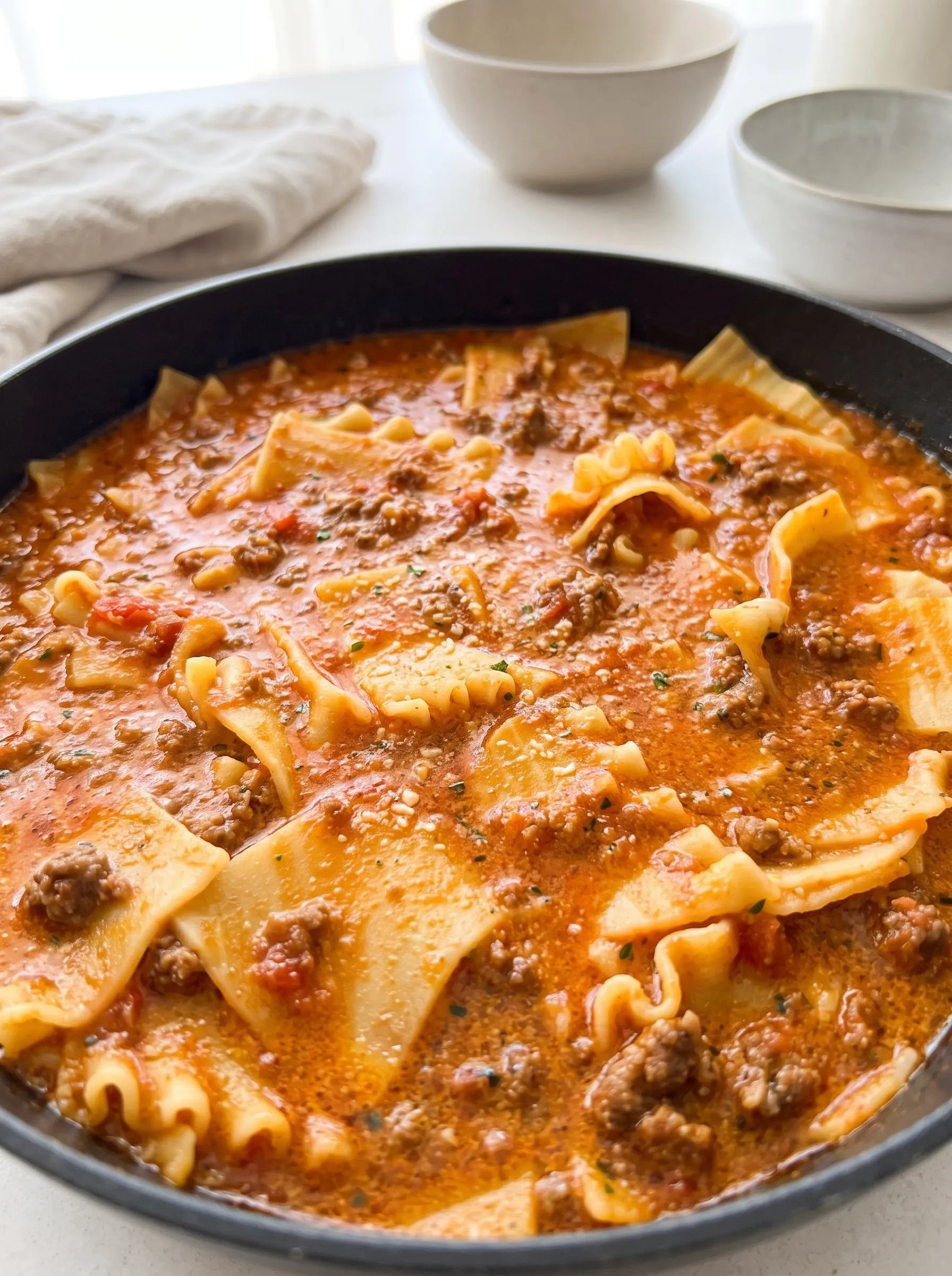 A bowl of pasta with meat and sauce.