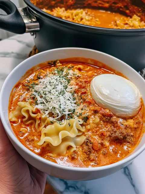 A bowl of pasta with cheese and meat.