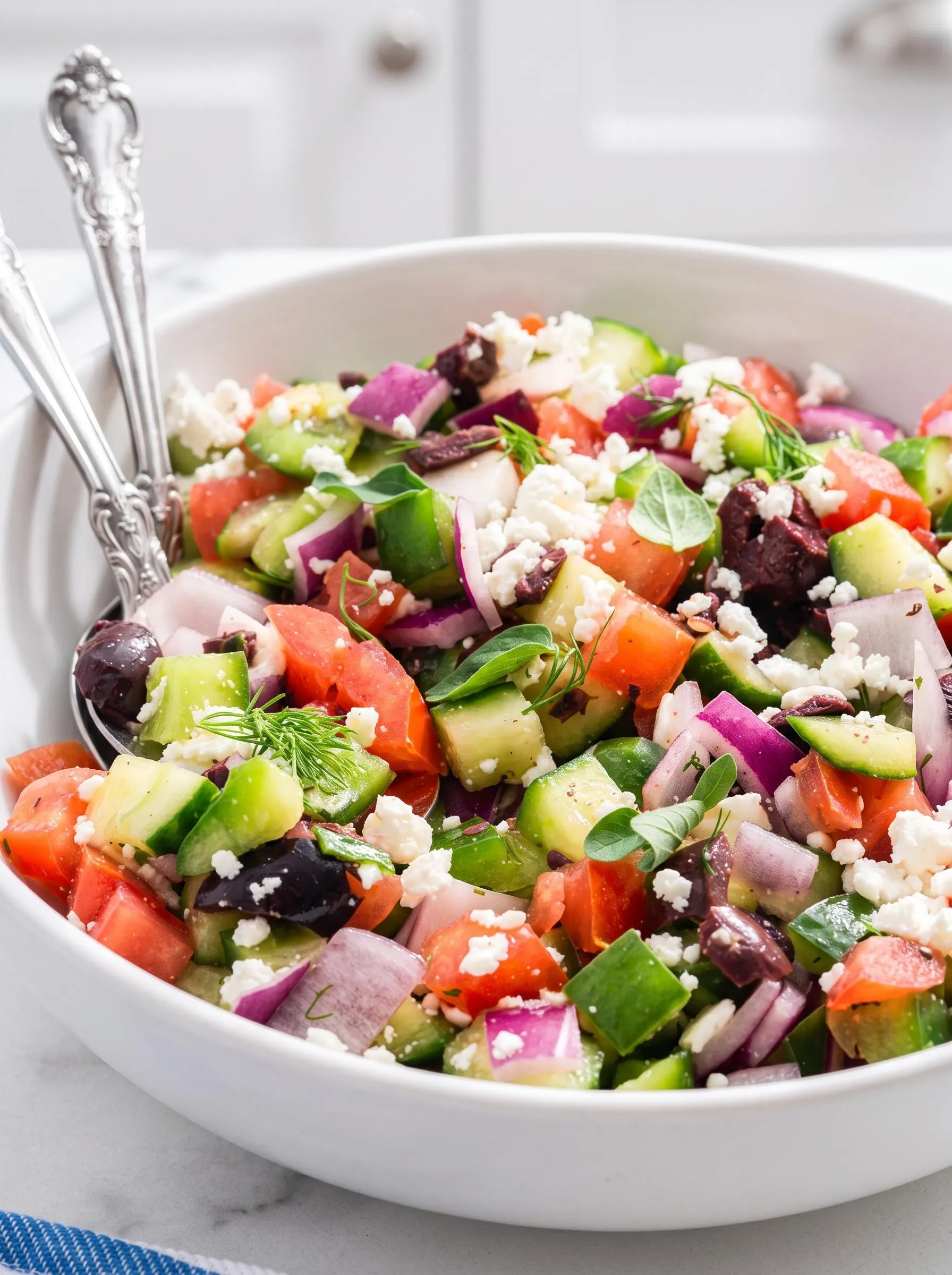 A white bowl filled with a Greek salad.