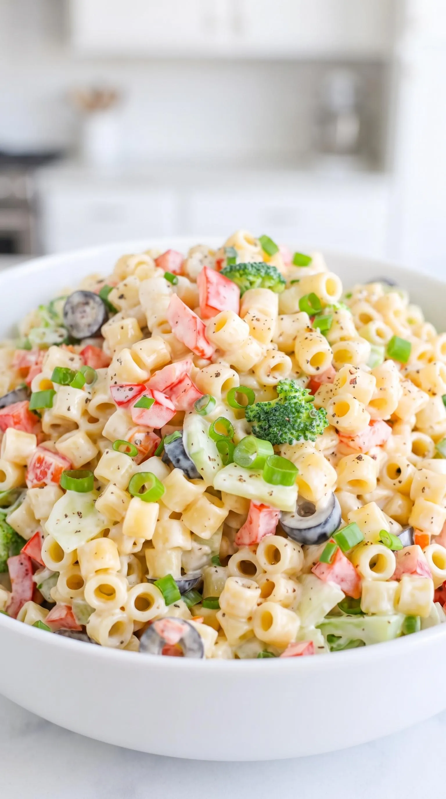 A bowl of pasta salad with broccoli and other vegetables.
