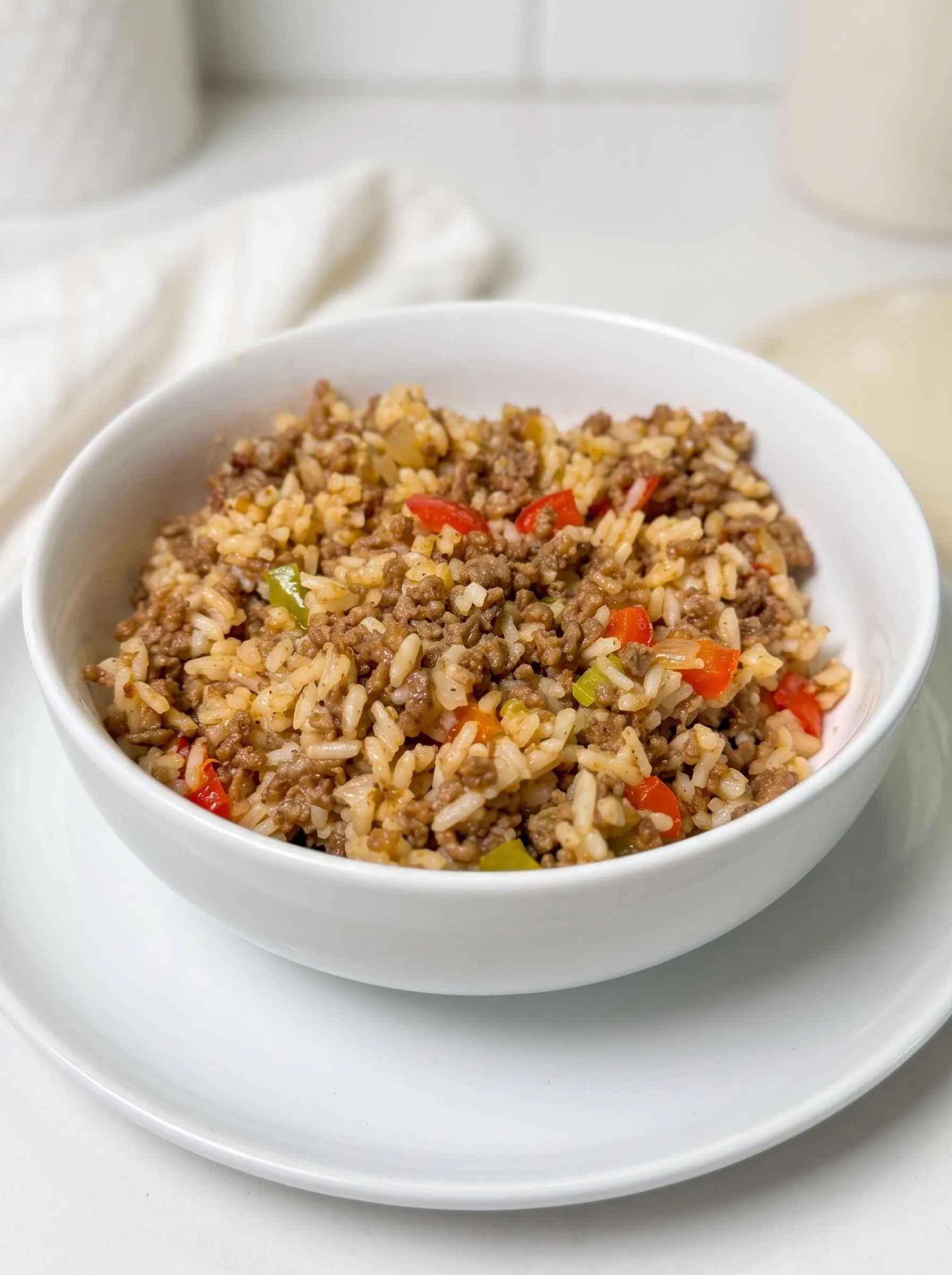A bowl of rice with meat and vegetables.