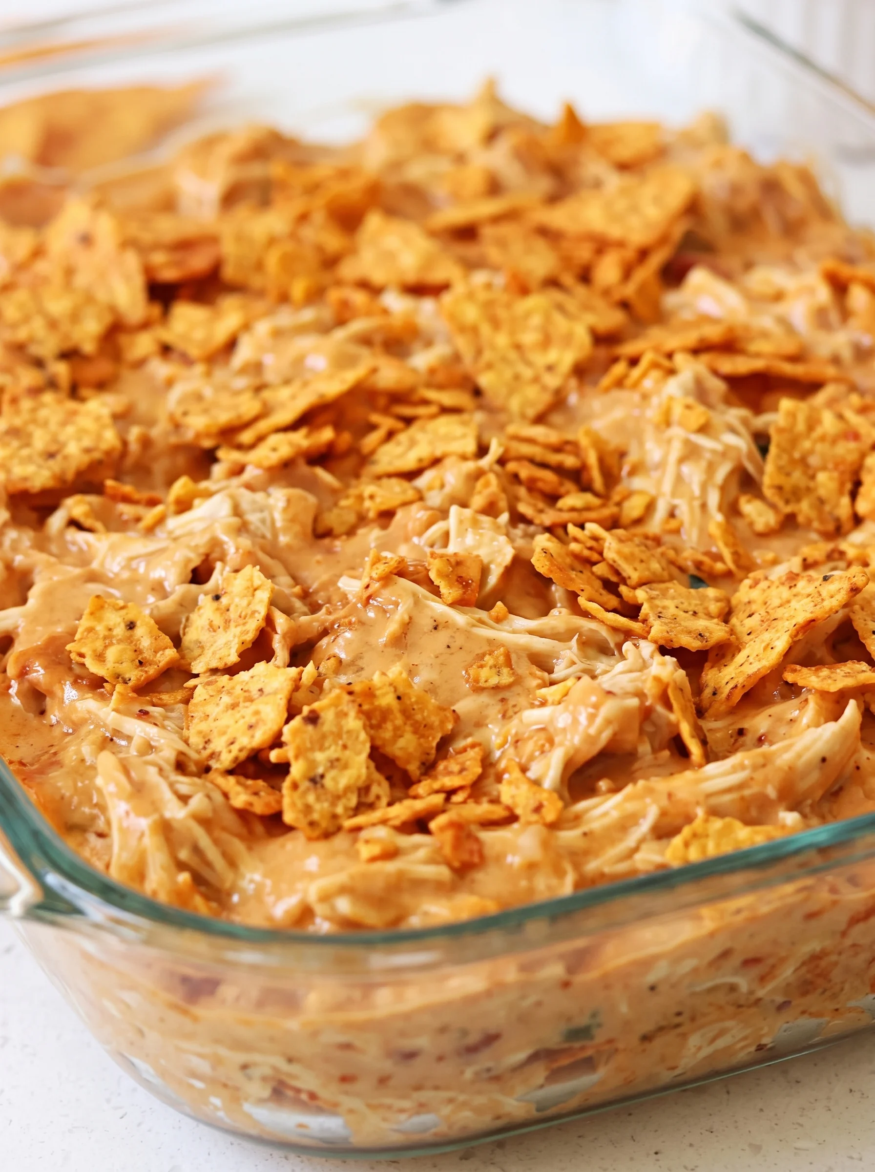 A bowl of chicken covered in Doritos chips.