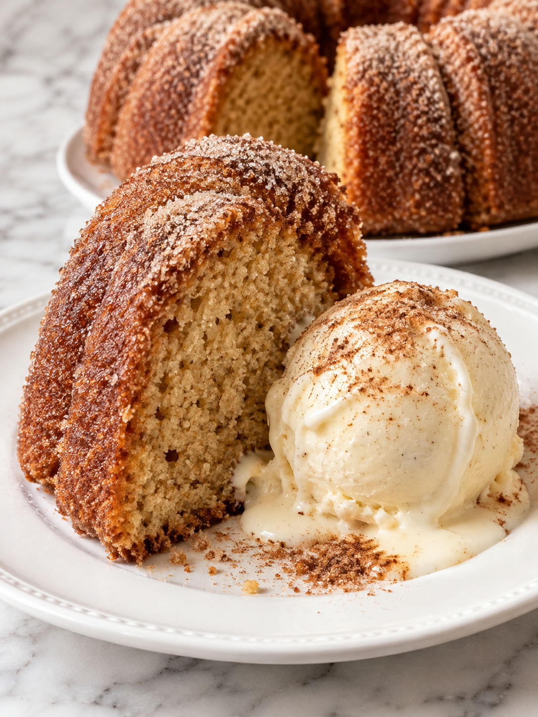 Warm apple cider donut cake slice with melting vanilla ice cream