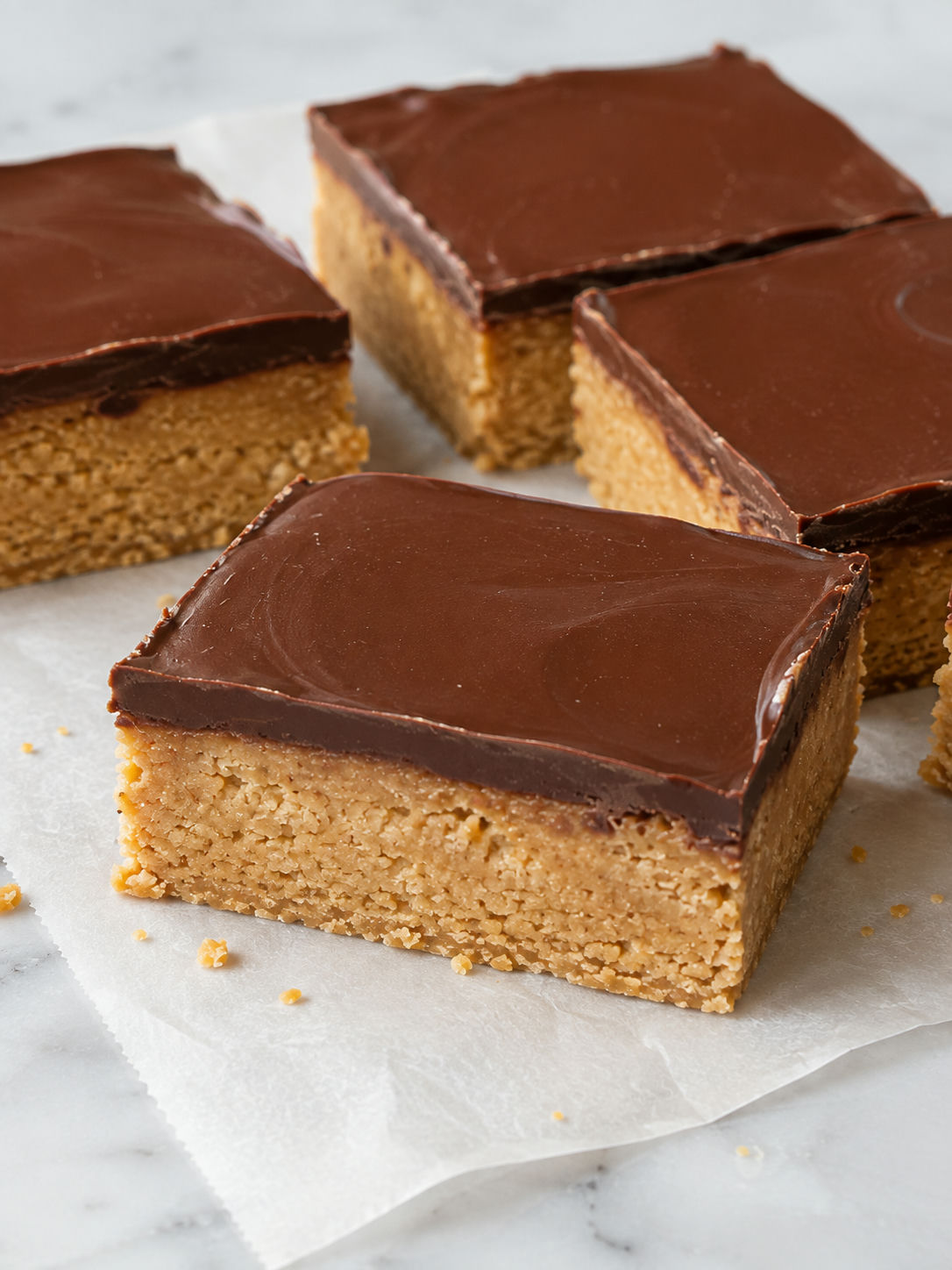 Thick peanut butter bars with smooth chocolate topping and graham crumbs