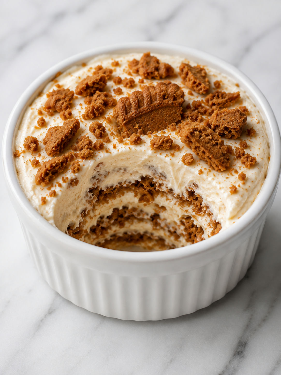 Creamy Biscoff yogurt cheesecake with softened cookie layers on a spoon