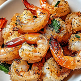 A bowl of shrimp with spices and seasonings.