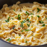 A bowl of pasta with herbs and spices.