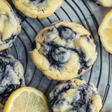 A plate of blueberry cookies with a lemon wedge on the side.