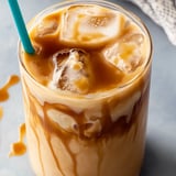 A glass of iced coffee with a blue straw.