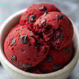 A bowl of red velvet cupcakes with chocolate chips.
