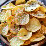 A bowl of chips with cheese on top.