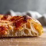 A slice of pizza on a wooden table.